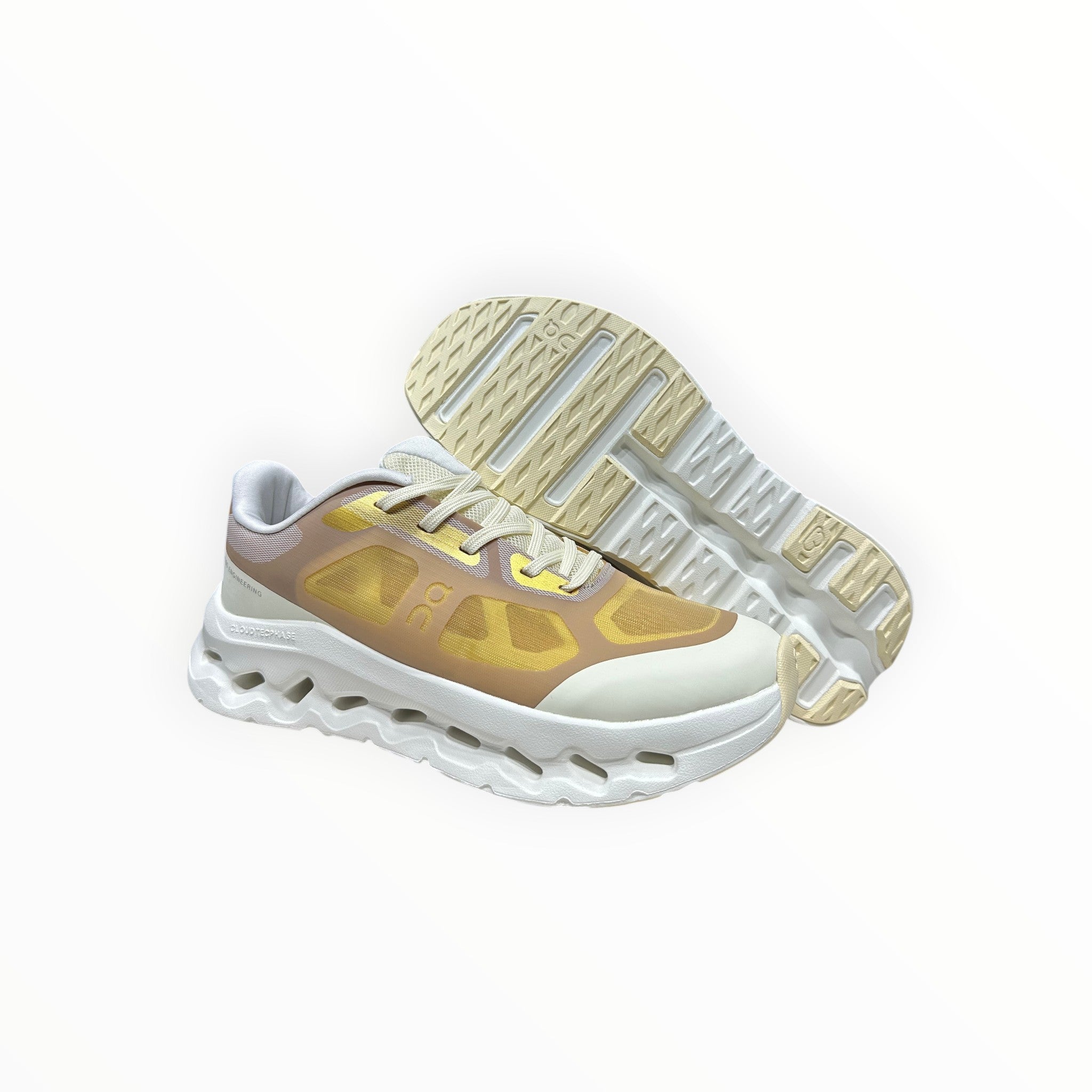 EWW Sports Shoes On Cloudtilt Remix gold and white sneakers with a layered, see-through upper and white chunky sole.
